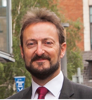 A man wearing a red tie and white shirt is smiling for the camera. AI generated content