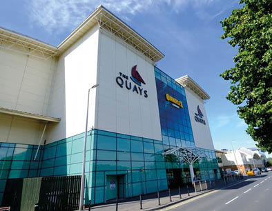 A large white building with a blue and red sign on the side. Description generated by AI