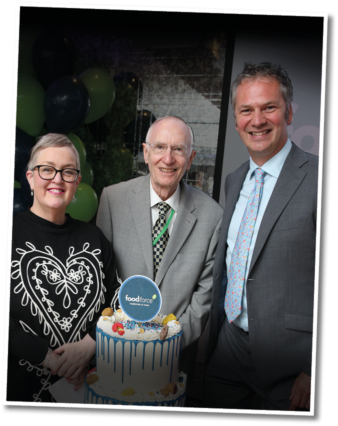 A man and woman are standing in front of a cake. Description generated by AI