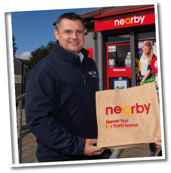 A man holding a brown bag with the word “nearby" on it. Description generated by AI