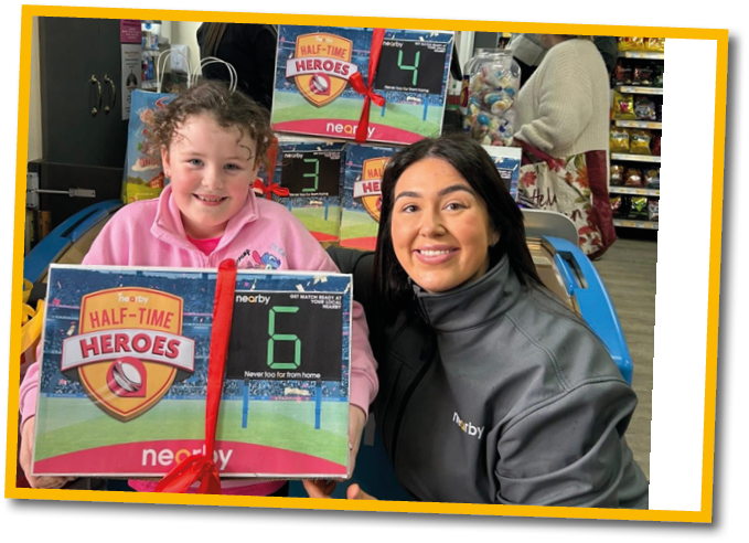 A woman and a girl are holding a box with a number 6 on it. Description generated by AI