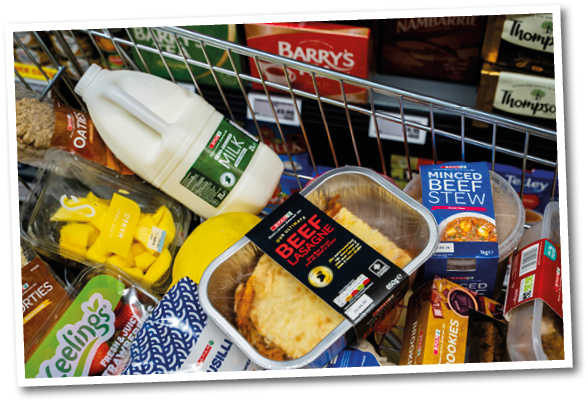 A cart full of food including milk, beef, and cake. Description generated by AI