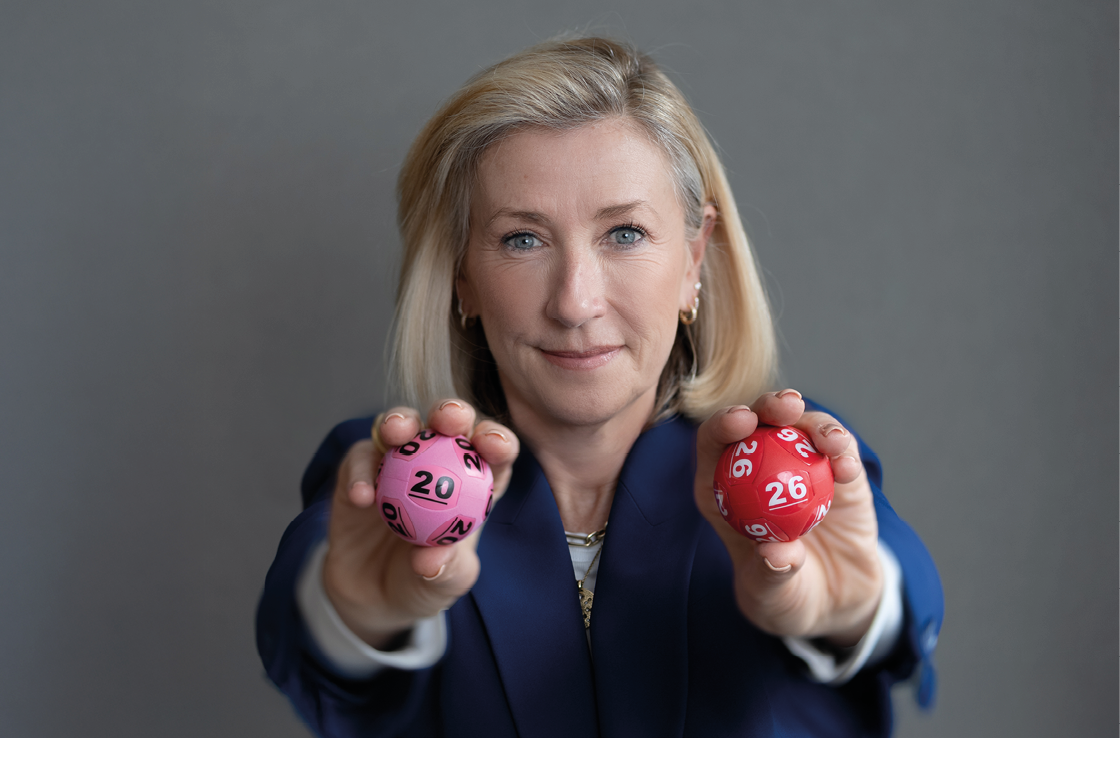 A woman holding two pink and red dice. Description generated by AI