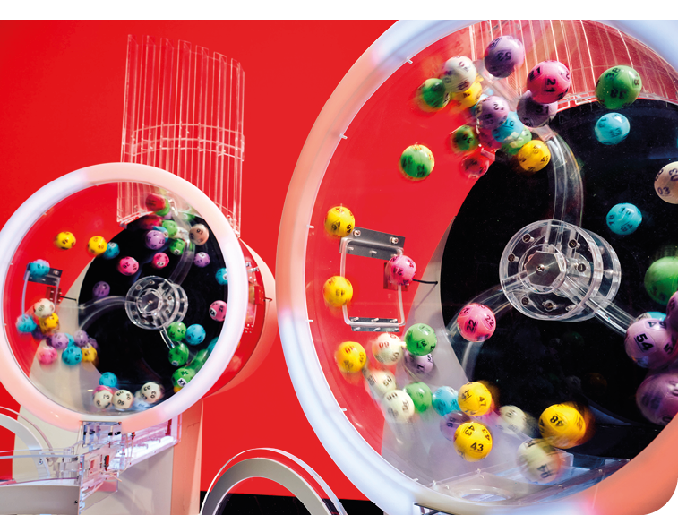 A red wall with a large wheel with colorful balls on it. Description generated by AI