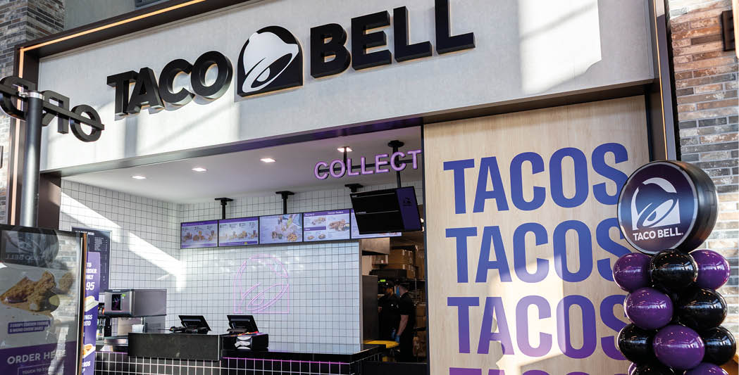 A purple and black balloon display in front of a Taco Bell restaurant. Description generated by AI