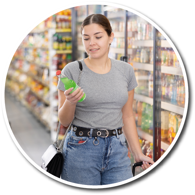 A woman holding a green bottle in a grocery store. Description generated by AI