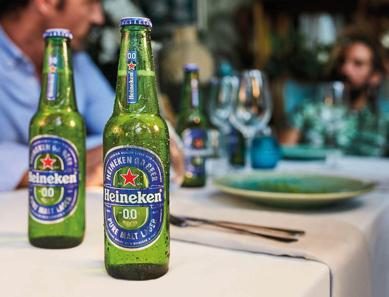 Three bottles of Heineken beer on a table. Description generated by AI