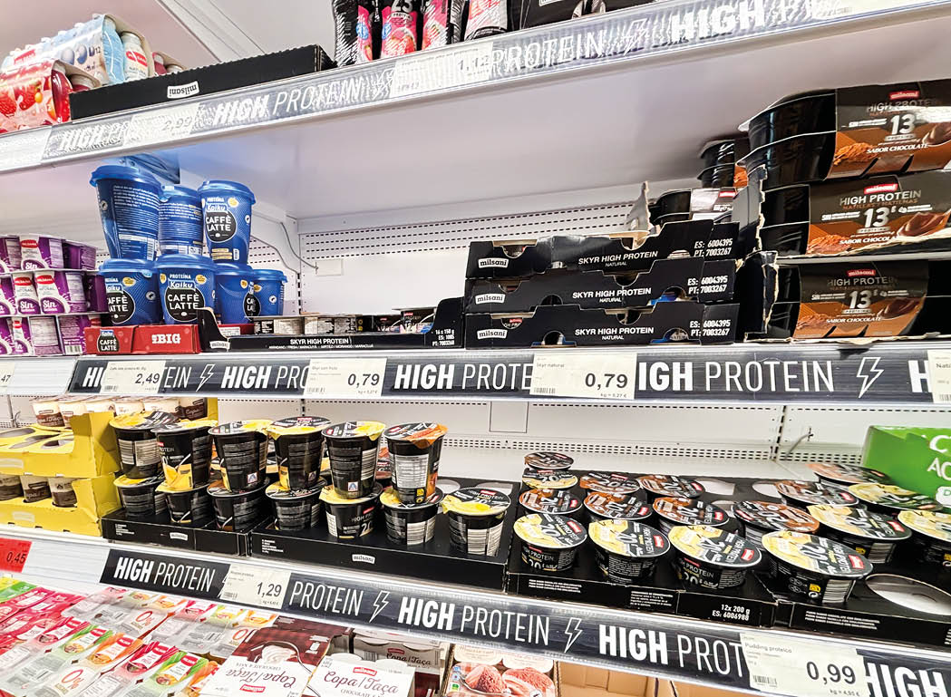 A grocery store with a shelf full of high protein products. Description generated by AI