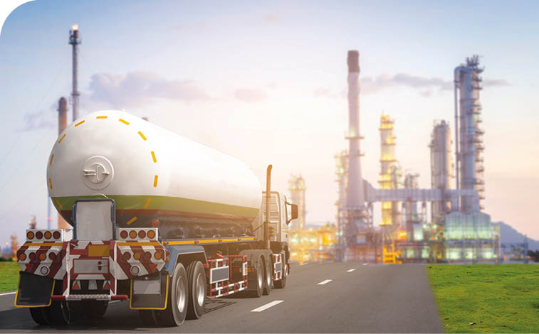 A large tanker truck is driving down a road. Description generated by AI