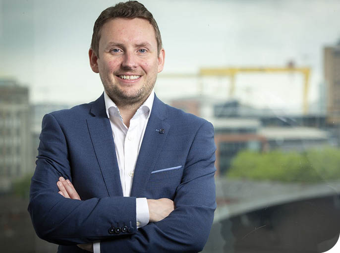 A man wearing a blue suit and white shirt. Description generated by AI