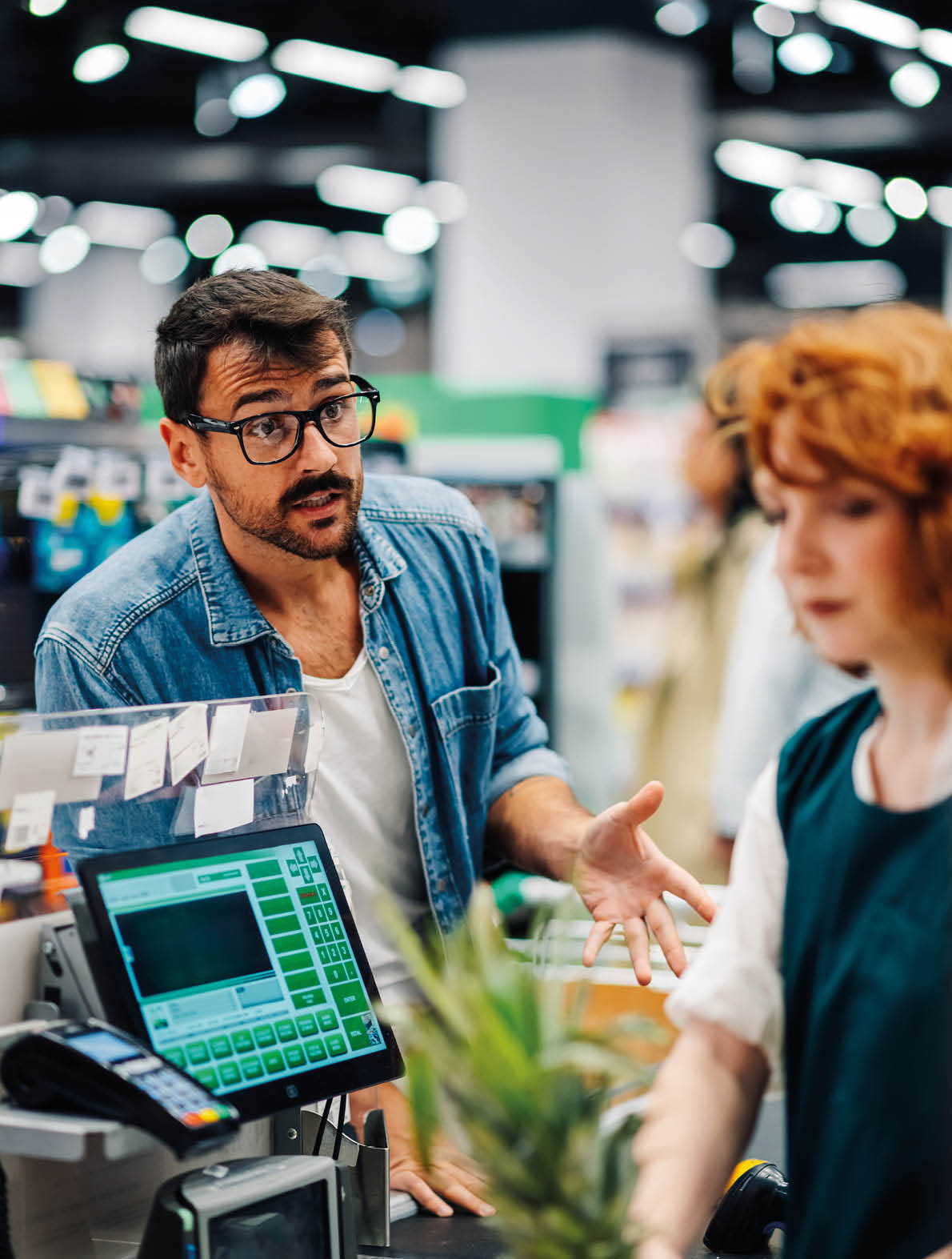 A man and a woman are standing in front of a cash register. Description generated by AI