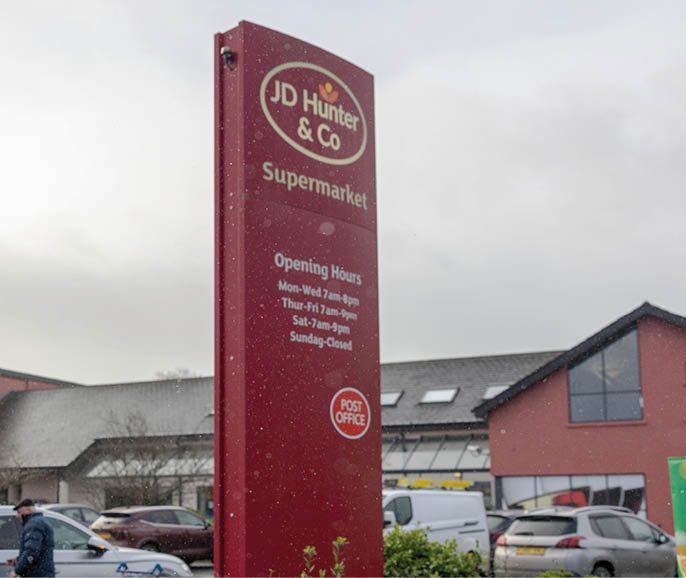 A red sign with white letters that says “JD Sports". Description generated by AI