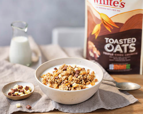 A bowl of cereal with chocolate chips and a bag of toasted oats. Description generated by AI