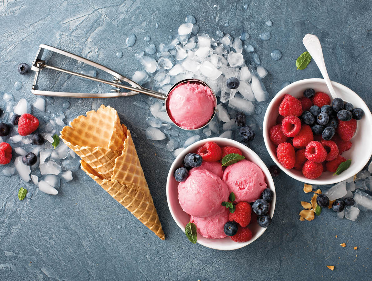 Raspberry ice cream in white bowl overhead shot