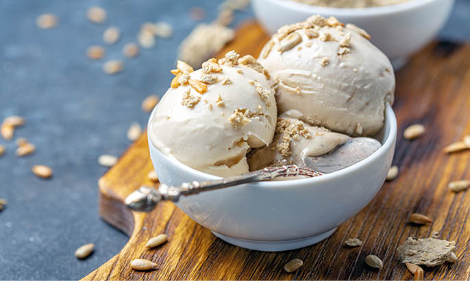 Homemade sundae with sunflower oil and halva in a white ceramic bowl close-up, selective focus.