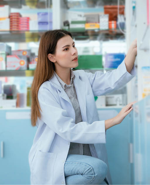 A female pharmacist checks drug stocks in a community pharmacy.