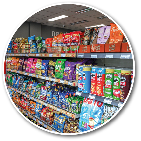 Shelves in a store stocked with a variety of colorful packaged snack foods including chips and crisps. Description generated by AI