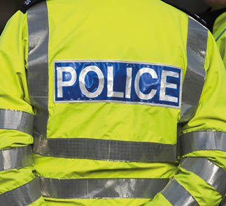 Shot of the back of a police officer's jacket with the word police written across the back