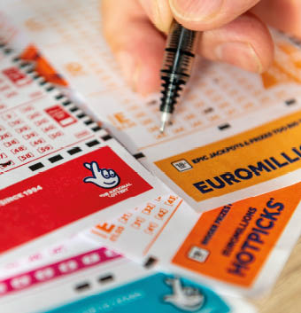 London. UK- 11.20.2022. A person marking the numbers on a lottery coupon.