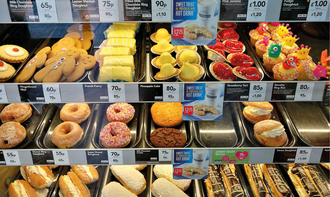 Glasgow, UK - 25th May 2018: Doughnuts and other sweet pastry on the shelves of a local Greggs in New Gorbals district of Glasgow.