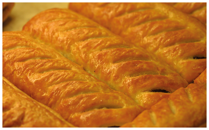 Freshly baked greggs sausage rolls in a shop window