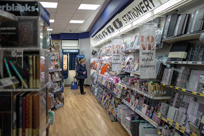 Cambridge, UK - Circa March 2019: Woman seen browsing the stationary section of a well known, British magazine and stationary seller. A large selection of books and stationary items are seen displayed