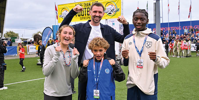 Sunday 27th July 2024 -Presseye Thousands of spectators lined the streets of Coleraine and packed the stands and terraces of the Coleraine Showgrounds to give a rousing welcome to over 1,200 elite young footballers from around the world as Northern Ireland legend Gareth McAuley  kicked-off an action-packed week of youth football with the official launch of the 2025 Budget Energy SuperCupNI.  Gareth McAuley pictured with Madisyn Tiano New York Rush Select  Concilio Tonebi West Ham Roman gaglio IDA  Photograph - Stephen Hamilton/Presseye