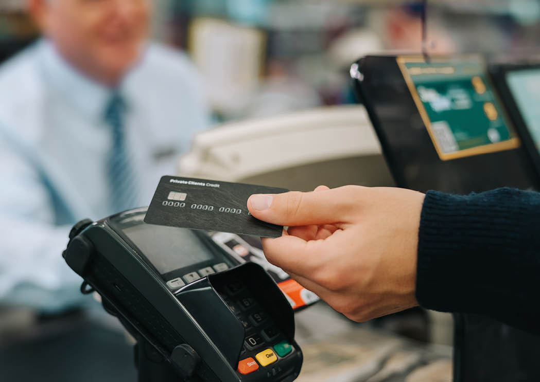 Close-up of a unrecognisable person using credit card to pay at grocery store. Customer making a payment for the purchase using his nfc card at supermarket.