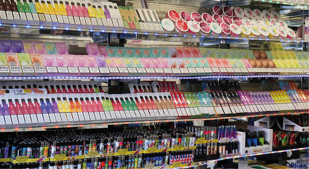 London, UK 08 28 2024 Rows of vibrant disposable electronic cigarette vapes and lighters stacked on shelves in a tourist shop in the city