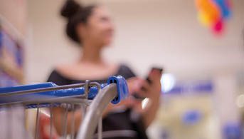 Sale, shopping, consumerism and people concept - happy young woman with smartphone choosing and buying food in market