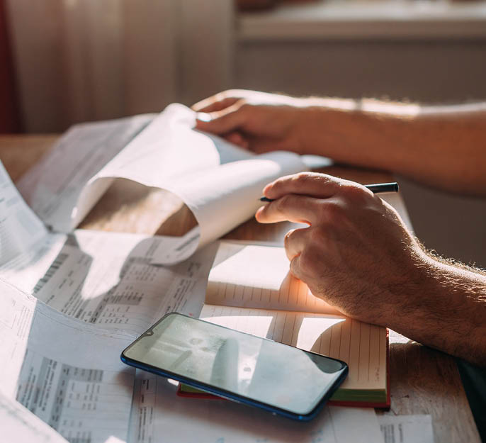 Close-up of men's hands with a calculator and utility bills. The concept of rising prices for heating, gas, and electricity. Lots of utility bills and hands with a calculator and a notebook