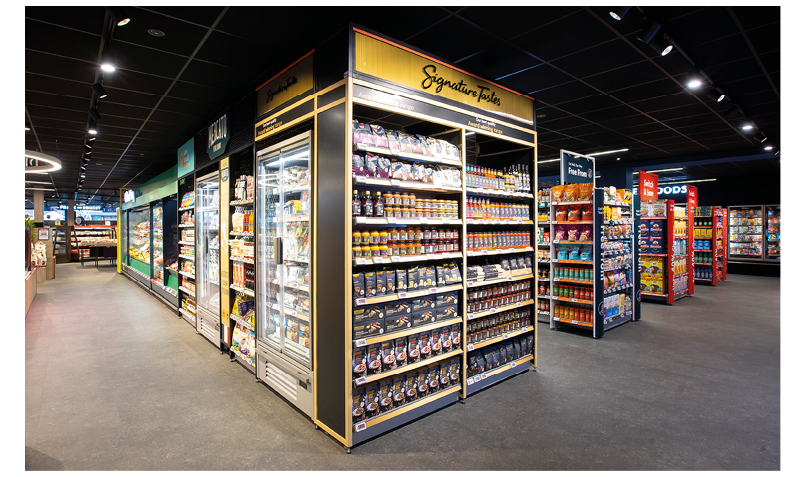 A well-lit supermarket aisle features neatly stocked shelves with various packaged food products and refrigerated items. Description generated by AI