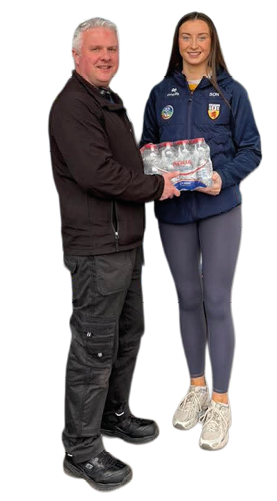 Two people stand side by side smiling while holding a pack of bottled water, with one wearing a dark jacket and pants and the other wearing a navy blue jacket and gray leggings. Description generated by AI