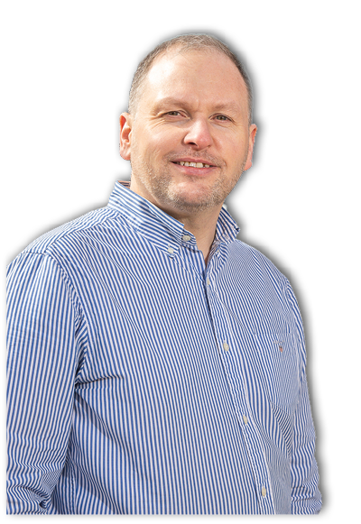 A person with short hair is smiling and wearing a blue and white striped button-up shirt against a white background. Description generated by AI
