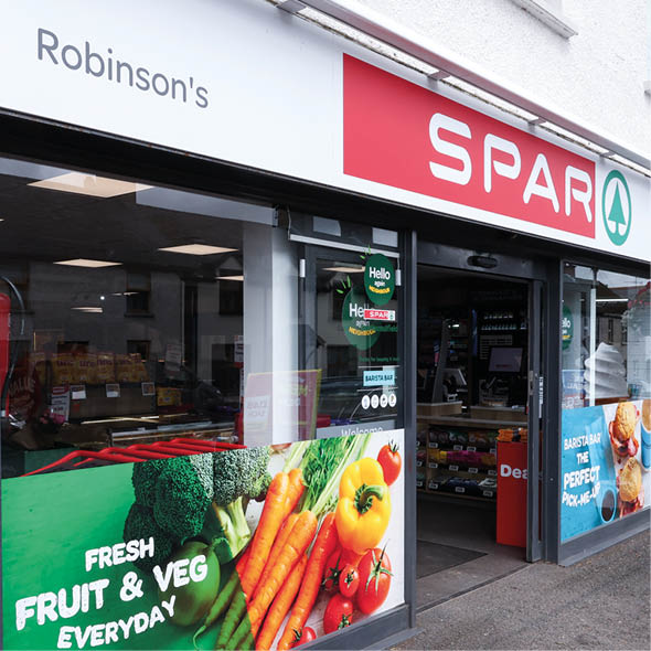 A storefront of Robinson's Spar convenience store with promotional signs for fresh fruit and vegetables and a large ice cream cone model outside. Description generated by AI