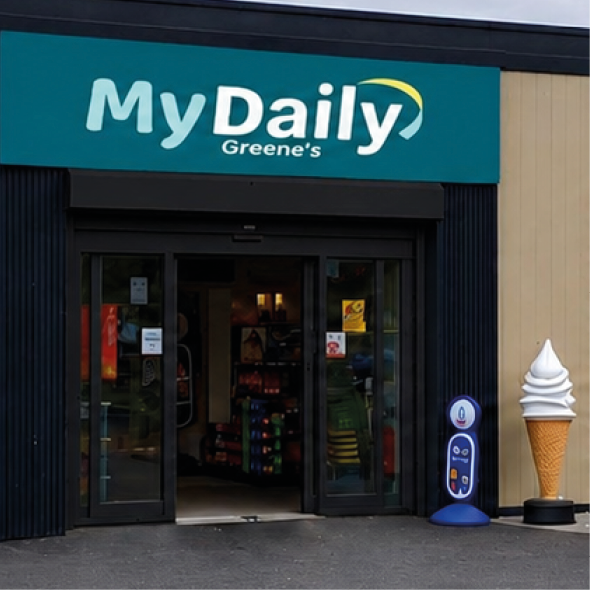 A modern convenience store named MyDaily with promotional posters for food and beverages displayed on the exterior walls and a large paved area in front. Description generated by AI