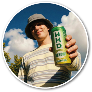 A person wearing a striped long-sleeve shirt and a bucket hat is smiling and holding a green can of WKD Venom cocktail against a blue sky with clouds. Description generated by AI