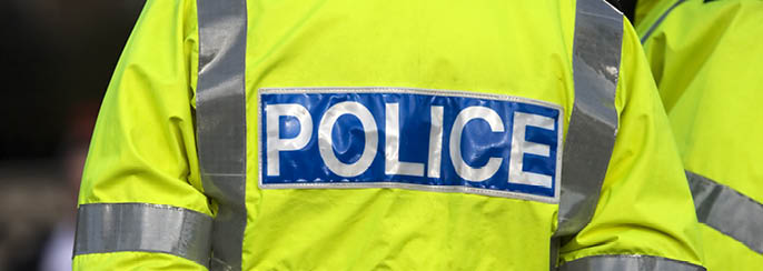 Shot of the back of a police officer's jacket with the word police written across the back