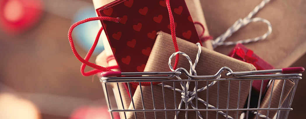 Shopping basket and gifts for Valentine's or Christmas with color bokeh on background