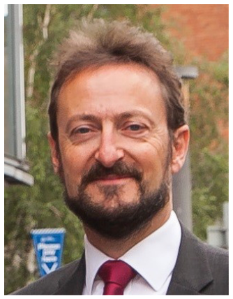 A man wearing a suit and tie is smiling for the camera. AI generated content