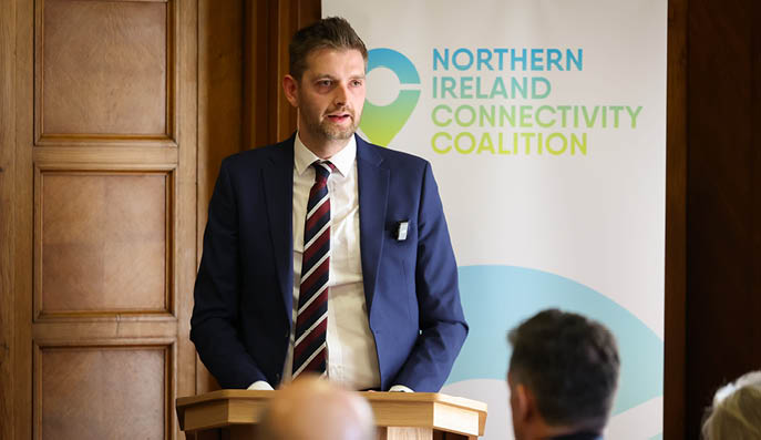 A man in a suit stands at a podium, giving a speech to a group of people. AI generated content