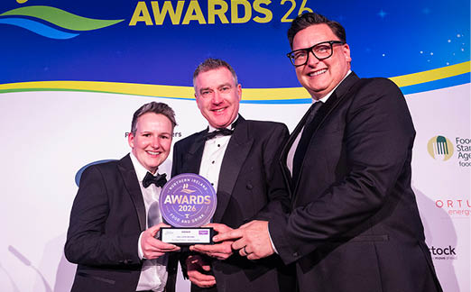 Three people are standing on a stage, holding an award. One of the men is wearing a tie. AI generated content