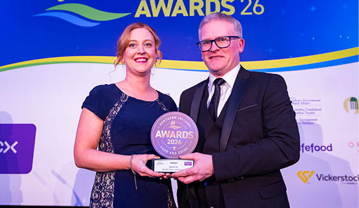 A man and woman are standing on stage holding a trophy. AI generated content