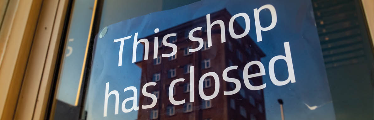 A window on a building with a sign that says “This shop has closed." AI generated content