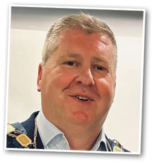 A man wearing a blue shirt and a chain around his neck is smiling. AI generated content