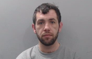 A man with a beard and mustache is sitting in a grey shirt. AI generated content