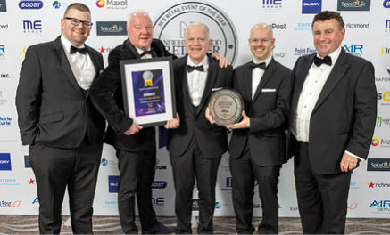 Four men in suits and ties pose for a picture, holding a trophy. AI generated content