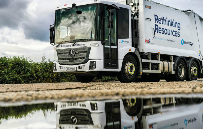 A large white garbage truck is parked on a wet road. AI generated content