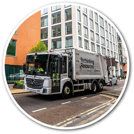 A large white truck is driving down a city street, passing by tall buildings. AI generated content