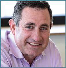 A man wearing a purple shirt is smiling at the camera. AI generated content